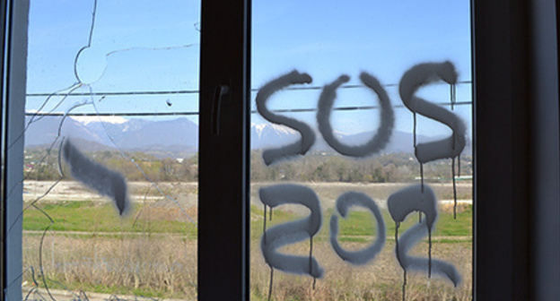 Inscription ‘SOS’ on the window of dilapidated house of cottage settlement for Olympic resettlers, Vesyoloe-Psou neighbourhood, Adler District of Sochi. Photo by Svetlana Kravchenko for the ‘Caucasian Knot’.