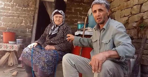 Ramazan Djalaldinov with an elderly woman in the village of Kenkhi. Screenshot of a video appeal