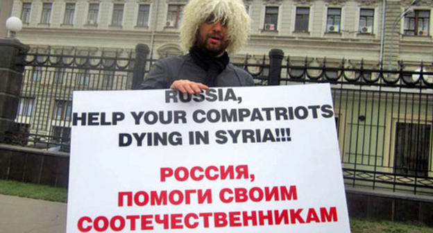 A Circassian activist with a poster standing at the solo picket. Photo: RFE/RL