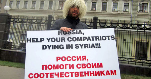 A Circassian activist with a poster standing at the solo picket. Photo: RFE/RL
