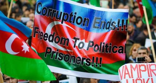 Participant of the rally holds flag of Azerbaijan with inscription demanding to stop corruption and to free political prisoners, Baku, October 28, 2017. Photo by Aziz Karimov for the Caucasian Knot. 