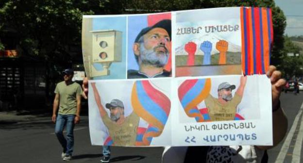 A resident of Yerevan with the posters saying, "Armenians, join us!", "Nikol is the Prime Minister of Armenia". Photo by Tigran Petrosyan for the "Caucasian Knot" A resident of Yerevan with the posters saying, "Armenians, join us!", "Nikol is the Prime Minister of Armenia". Photo by Tigran Petrosyan for the "Caucasian Knot"