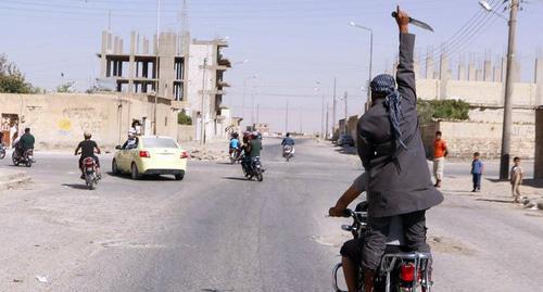A man holds khife above his head celebrating capture of Tabqa airbase by militants. Photo: REUTERS / Stringer