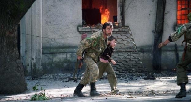 Fighter is taking a child away from the burning building in Sukhumi, 1993. Photo: Andrei Soloviev, RFE/RL Fighter is taking a child away from the burning building in Sukhumi, 1993. Photo: Andrei Soloviev, RFE/RL
