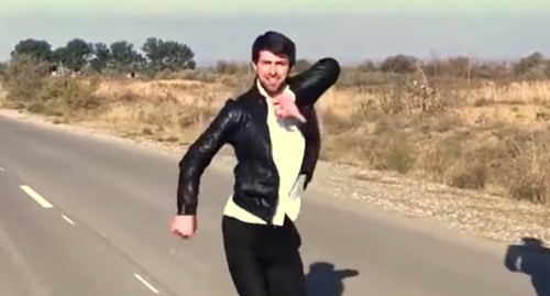 A young man dancing lezginka on the road. Screenshot from Murad Khatiev's video: https://www.youtube.com/watch?v=HNzJpO0Kk60