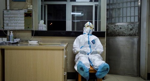 Health worker in a protective suit resting in a hospital in China's Wuhan, February 9, 2020. Photo: China Daily via Reuters