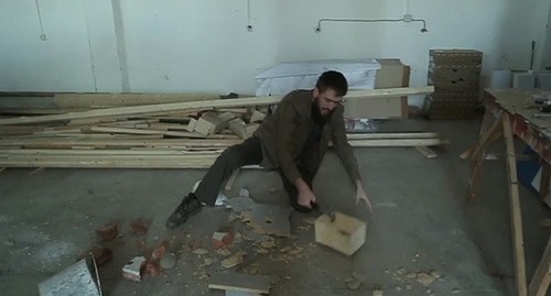Chingiz Akhmadov smashes bricks and a wooden tabletop with a hammer, and also leaves noticeable dents on a metal bucket and a construction helmet. Screenshot: https://www.instagram.com/p/B9TZgN4IXm4/