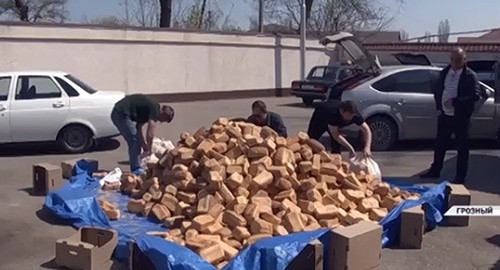 Spreading bread to poor families. Screenshot from video posted by groznytv: https://www.instagram.com/p/B-31k0kFn62/