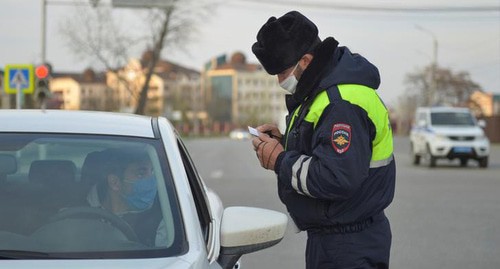 Law enforcer checking documents of a car driver, Chechnya, April 2020. Photo: REUTERS/Ramzan Musaev