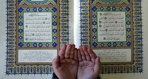 A child's hands and the Quran. Photo: REUTERS/Ali Jarekji AJ/THI