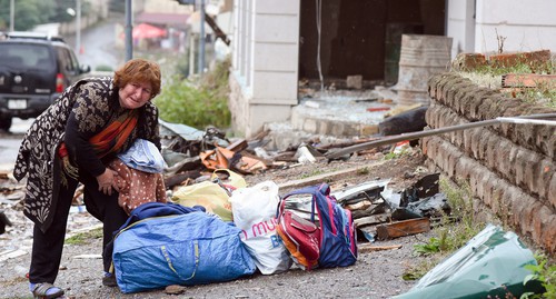 A woman rendered homeless gathers her belongings, October 6, 2020. David Kagramanyan / the information centre of NKR / PAN Photo / Reuters