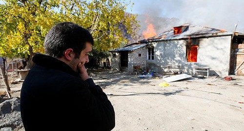 A resident of Nagorno-Karabakh near a burning house. November 2020. Photo: REUTERS/Stringer