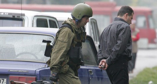 A law enforcer escorts an arrested man. Nalchik, October 14, 2005. Photo: REUTERS/Viktor Korotayev