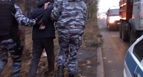 Law enforcers accompany a detained person. Photo: press service of the National Antiterrorist Committee, http://nac.gov.ru/
