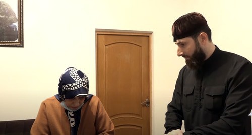 Zarema Makhmudova, a resident of the Gudermes District, and the theologian, Adam Elzhurkaev. Screenshot of the video by the "Grozny" TV Channel https://www.youtube.com/watch?v=DPch-luKpbk&amp;feature=emb_logo