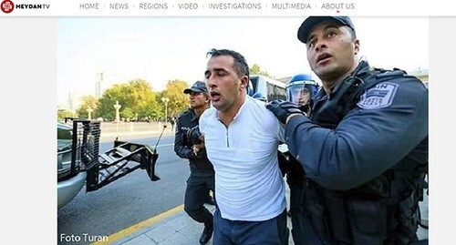Policemen detaining Niyameddin Akhmedov. Screenshot: Meydan.TV