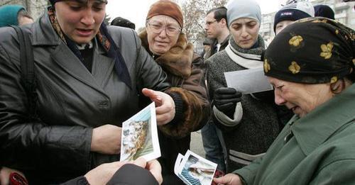 Relatives of the victims in the attack on Nalchik are looking at their pictures. Nalchik, November 29, 2005. Photo: REUTERS/Viktor Korotayev