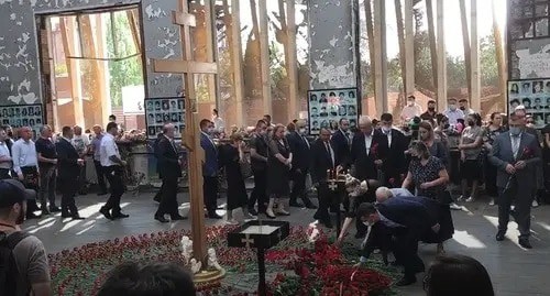 People laying flowers at the Beslan school, which was seized by terrorists 17 years ago. Screenshot from video posted by News Time: http://www.youtube.com/watch?v=8d3og_2uhis