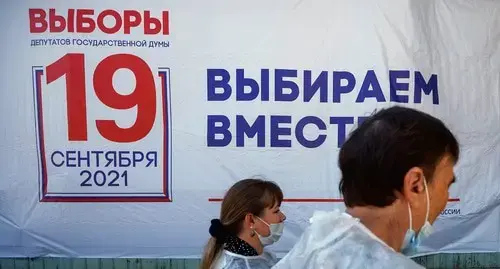 Members of local electoral commission walk past the electoral board on the first day of three-day parliamentary elections in Russia, September 17, 2021. Photo: REUTERS/Maxim Shemetov