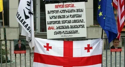 The flag of Georgia and a poster with inscription: "You should know it all! People will not be left in prison! World reformer Misha! Go out to rallies!.. Down with!.. Abductors of the elections, thieves-occupiers!!!..."; Photo by Inna Kukudzhanova for the Caucasian Knot