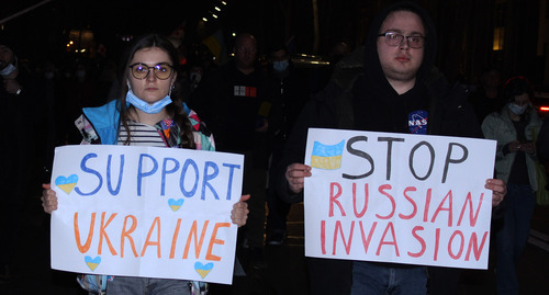 Protesters holding posters saying, "Support Ukraine" and "Stop Russian invasion."