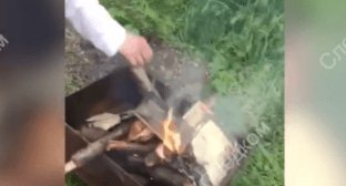 A young man puts the New Testament into the fire in a portable grill. Screenshot of the video posted by the Branch for the Stavropol Territory of the Investigating Committee of the Russian Federation on May 3, 2024 https://t.me/su_skr26/3115