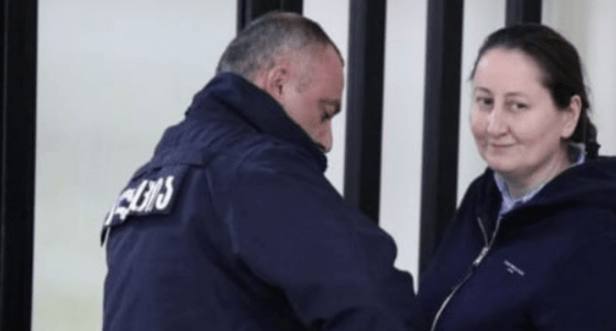 Mziya Amaglobeli (right) and a police officer. Screenshot of a photo by the Interpressnews posted on February 27, 2025, https://www.interpressnews.ge/ru/article/167011-advokat-mziia-amaglobeli-vypisana-iz-vivamed-i-trebuet-perevoda-v-penitentsiarnoe-uchrezhdenie-odnako-penitentsiarnaia-sluzhba-ee-ne-perevodit
