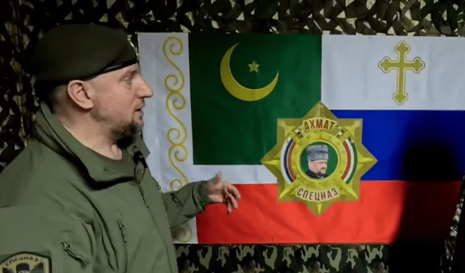 Apti Alaudinov is standing against the background of the “Akhmat” special forces flag. A screenshot from a video posted on the Anastasia Babir’s Telegram channel on May 23, 2025, https://t.me/SovaBabir/217.
