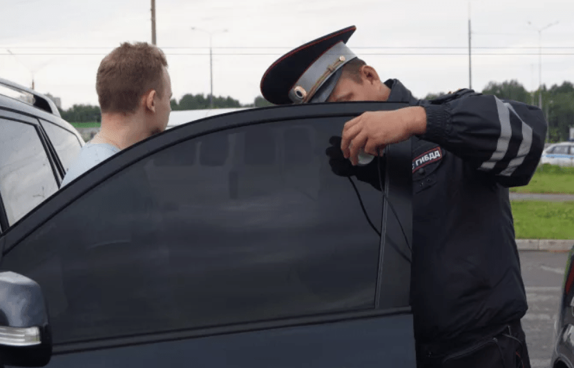 A police officer checks the tint level. Screenshot of the photo https://35.мвд.рф/news/item/17740359?year=2019&month=11&day=24.