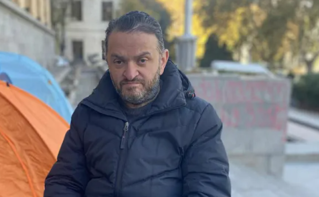 Gedevan Popkhadze. Screenshot from Interpressnews photo from November 23, 2025, https://www.interpressnews.ge/ka/article/855344-gedevan-popxaze-sxva-aktivistebtan-ertad-parlamenttan-shimshilobas-27-e-dgea-ganagrzobs
