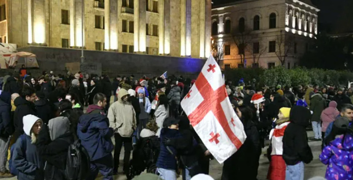 Protesters outside the Georgian Parliament. Screenshot from Interpressnews photo from December 18, 2025, https://www.interpressnews.ge/ka/article/857705-parlamenttan-saprotesto-akcia-mimdinareobs
