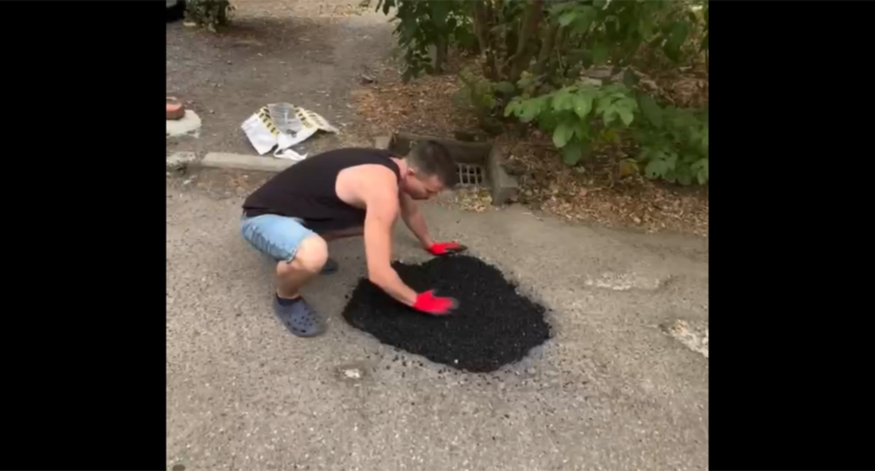 A resident of Krasnodar repairs the roadway in the courtyard. Frame from the video https://t.me/tipichkras/82566 A resident of Krasnodar repairs the roadway in the courtyard. Frame from the video https://t.me/tipichkras/82566