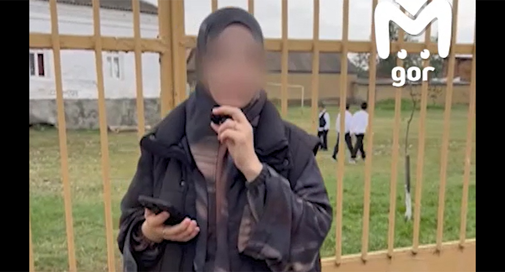 A resident of Aksai against the backdrop of the territory of school No. 2. Frame from the video https://t.me/mash_gor/11257 A resident of Aksai against the backdrop of the territory of school No. 2. Frame from the video https://t.me/mash_gor/11257